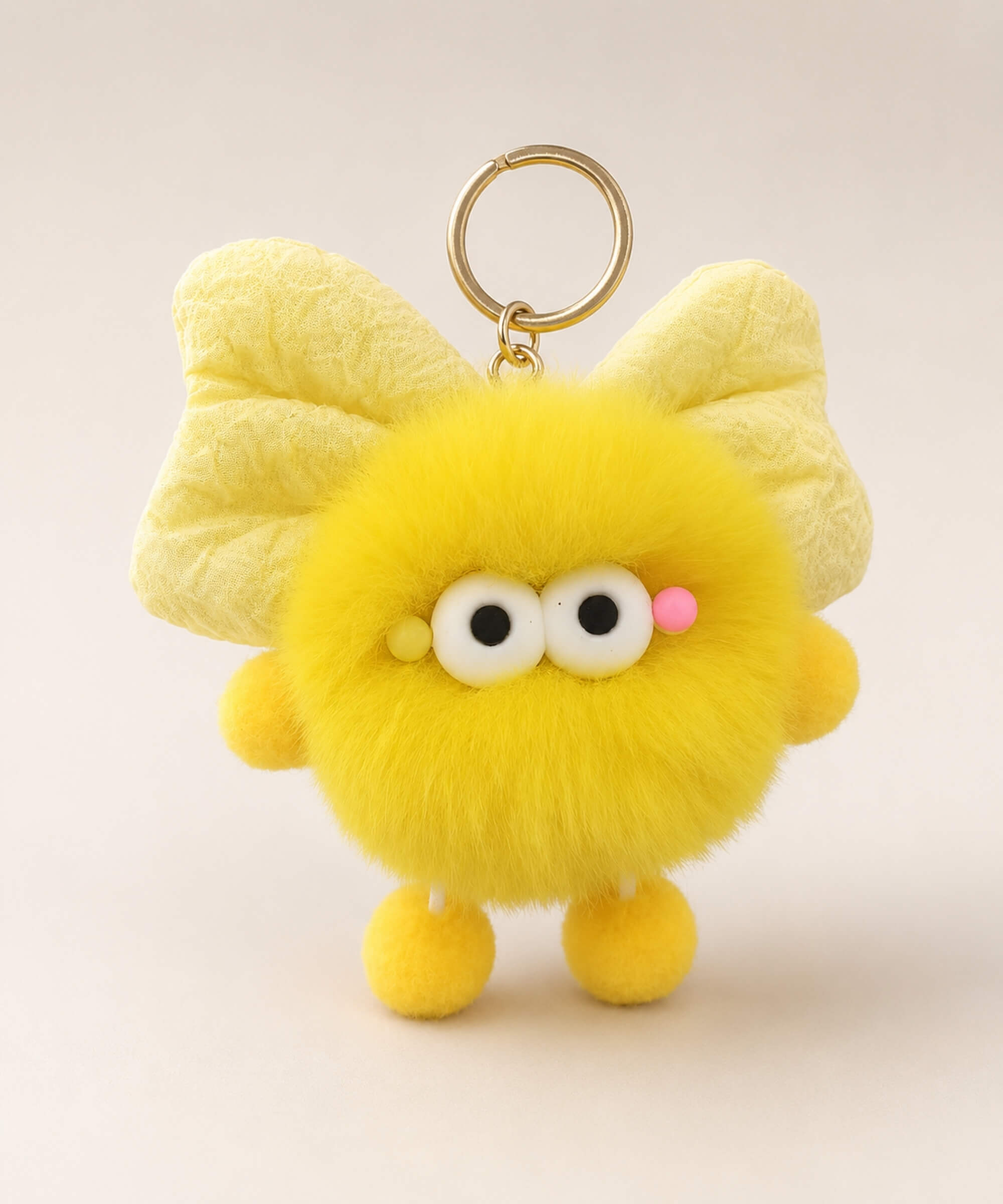 Yellow fluffy bow plush keychain with cute wide-eye detail and gold-tone hardware